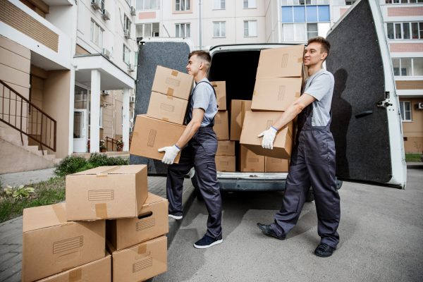 two-young-handsome-smiling-workers-wearing-uniforms-are-unloading-the-van-full-of-boxes-the-block[1]